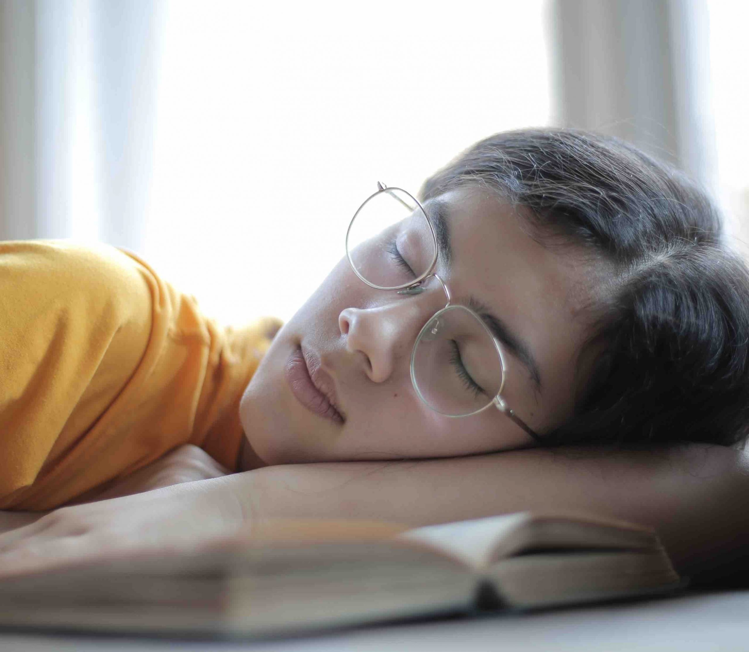 exhausted-female-student-sleeping-at-table-in-library-3808119 copy